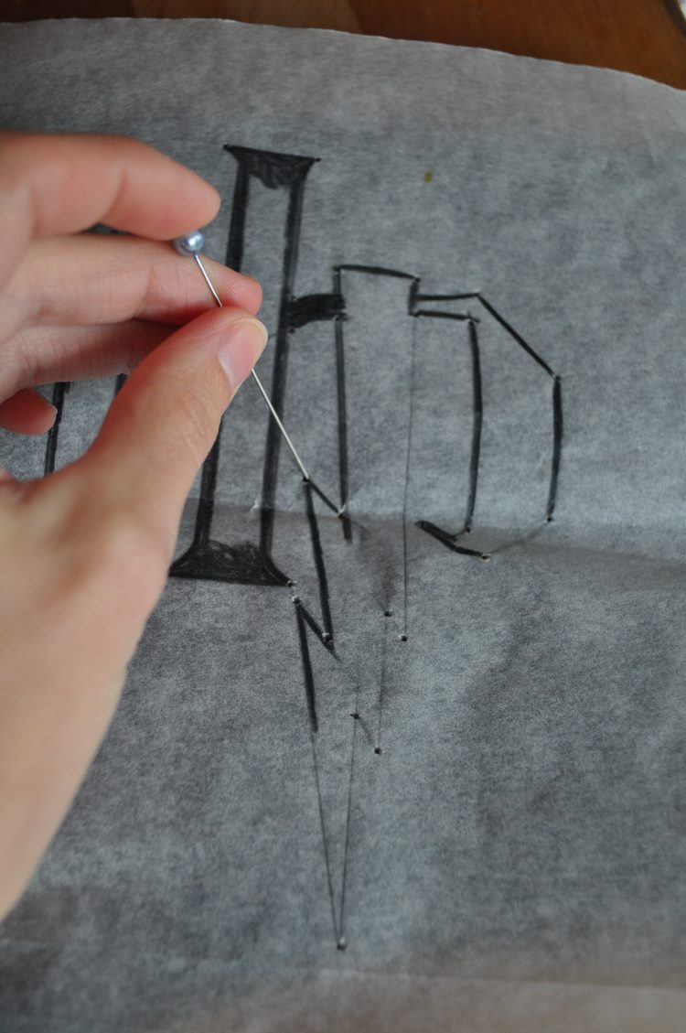 Vorzeichnen bzw. vorstechen mit einer Nadel für ein Lettering auf einem T-Shirt