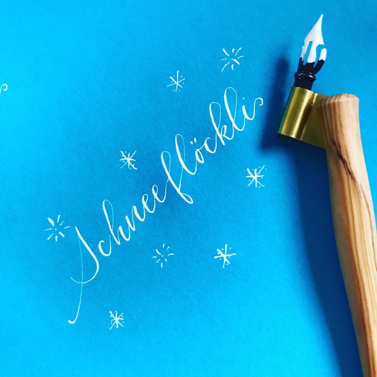 Schneeflöckli - Kalligrafie in weiss auf blauem Papier