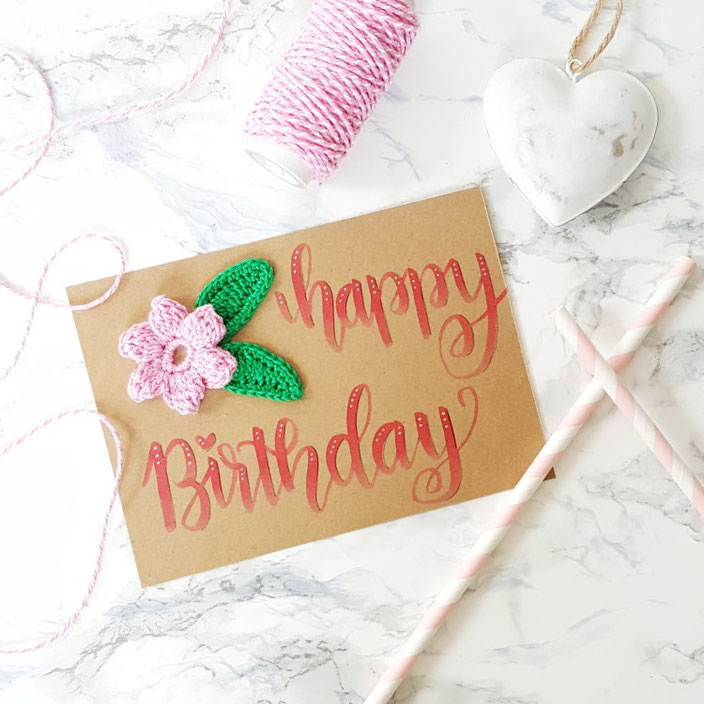 Happy birthday - Handlettering mit einer Häkelblume auf einer Karte