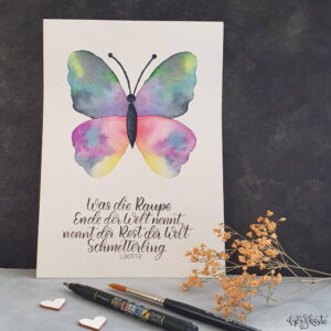 Aquarell Schmetterling mit einem Brush Lettering Spruch über die Raupe und den Schmetterling