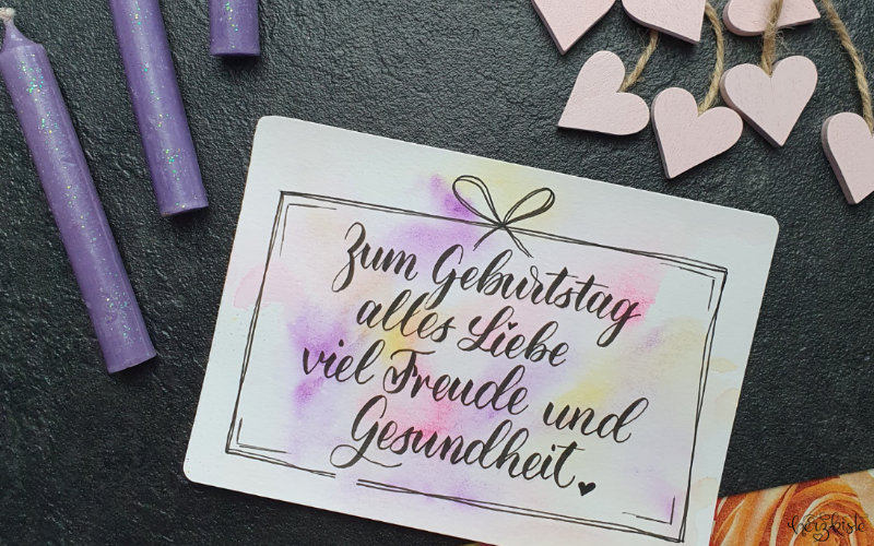 Lettering Geburtstagskarte auf farbigem Hintergrund mit dem Text als Geschenk verpackt